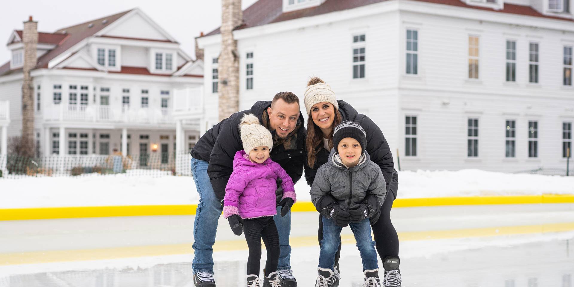 Family smiling at Inn at Bay Harbor ice rink