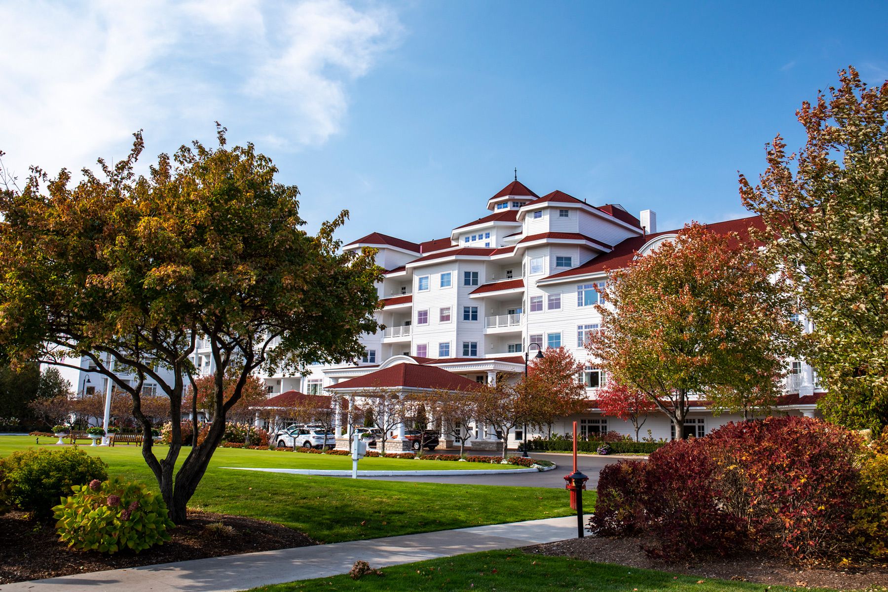 Autumn leaves on trees of Inn at Bay Harbor grounds under blue sky