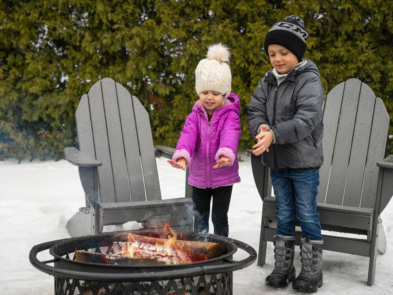 Kids warm hands near winter bonfire