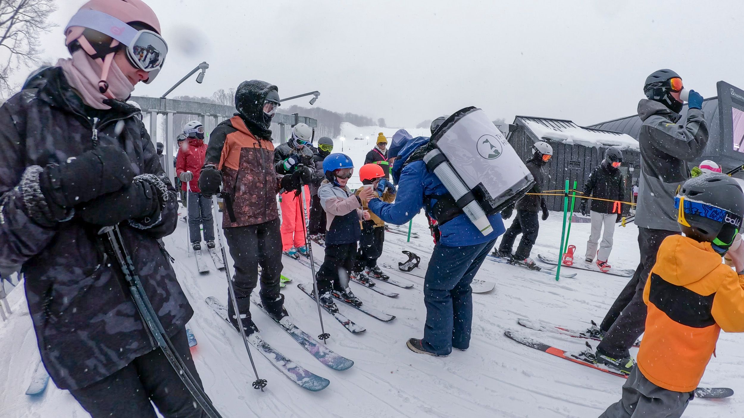 A team member giving hot cocoa in the lift line at The Highlands