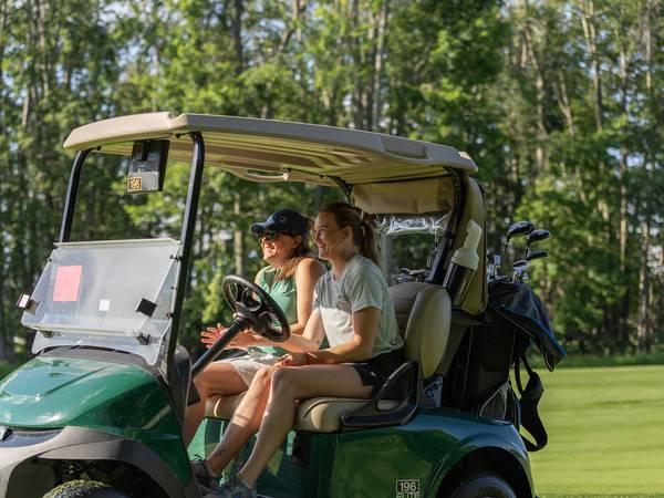 Two women in a golf cart