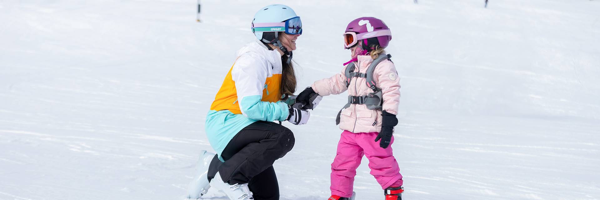 A mom and daughter in ski gear