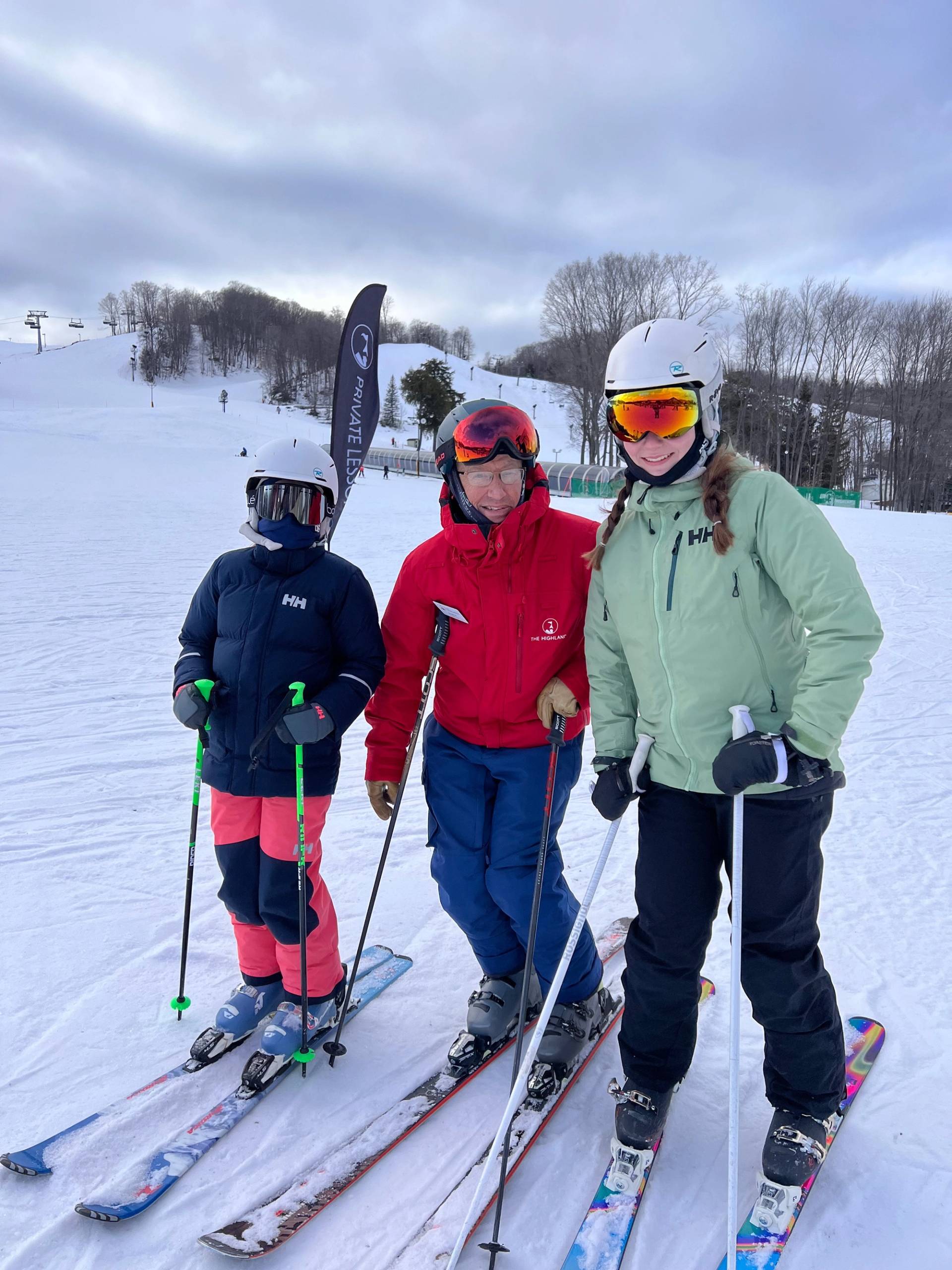 Two girls posing with their ski instructor