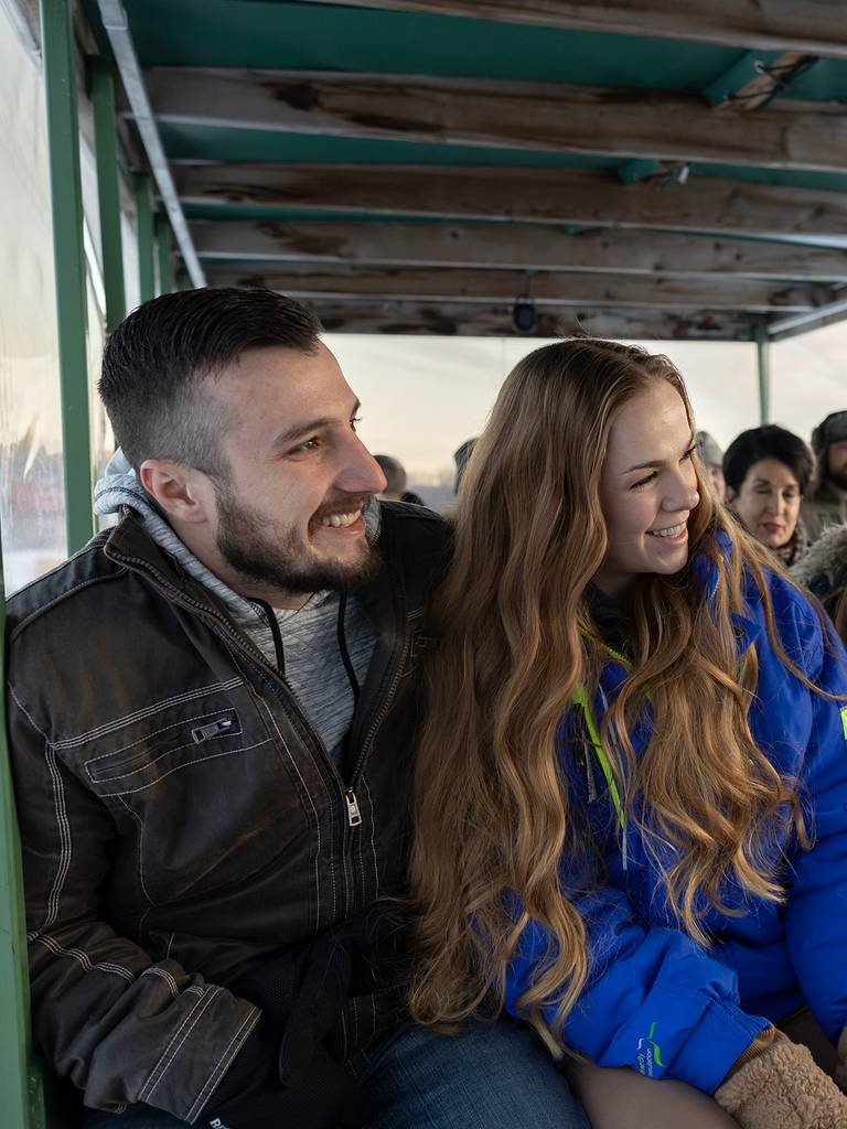 a group smiling on the sleigh ride up to North Peak at The Highlands