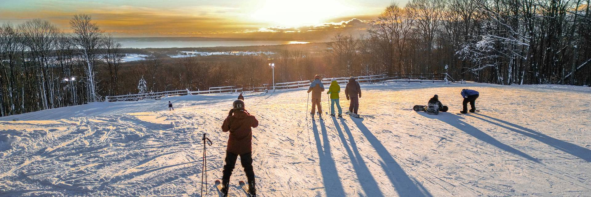 A group of skiers admiring the sunset at the top of the slopes at The Highlands