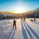 A group of skiers admiring the sunset at the top of the slopes at The Highlands