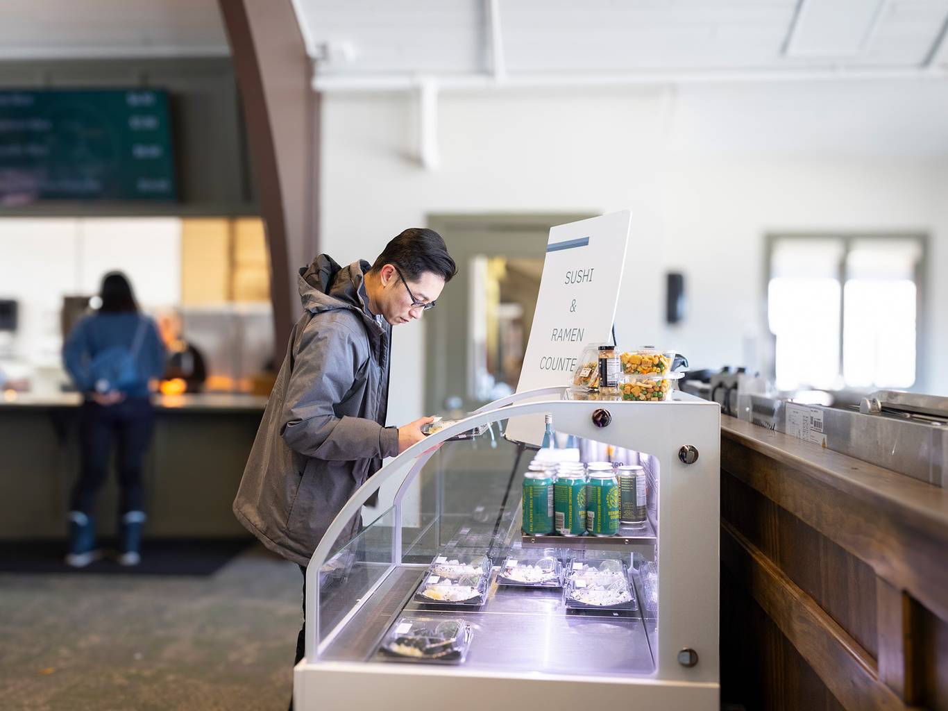 A man browsing sushi at the Food Market at The Highlands
