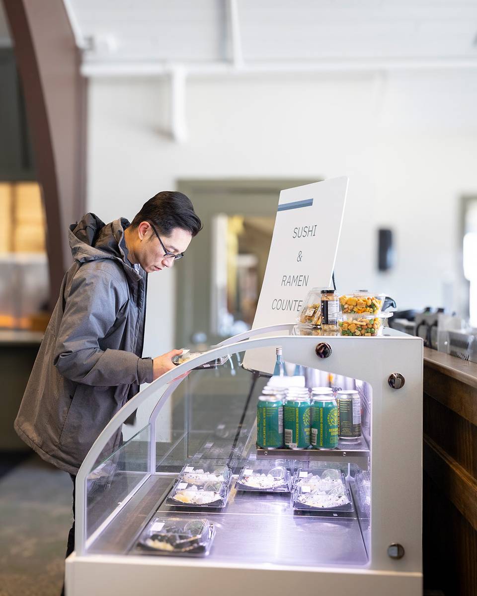 A man browsing sushi at the Food Market at The Highlands