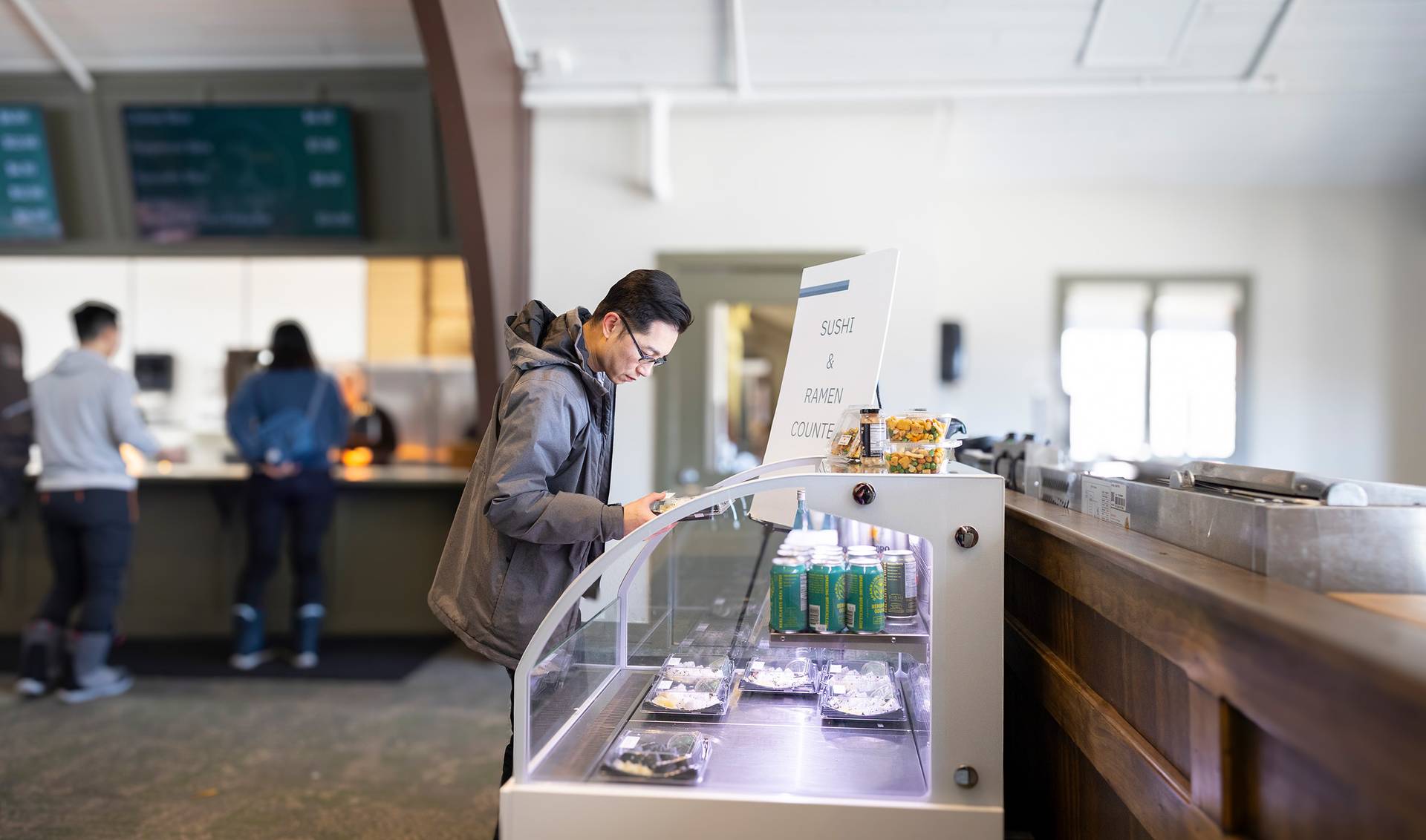 A man browsing sushi at the Food Market at The Highlands