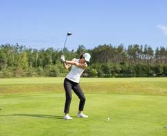 A woman golfing at The Highlands