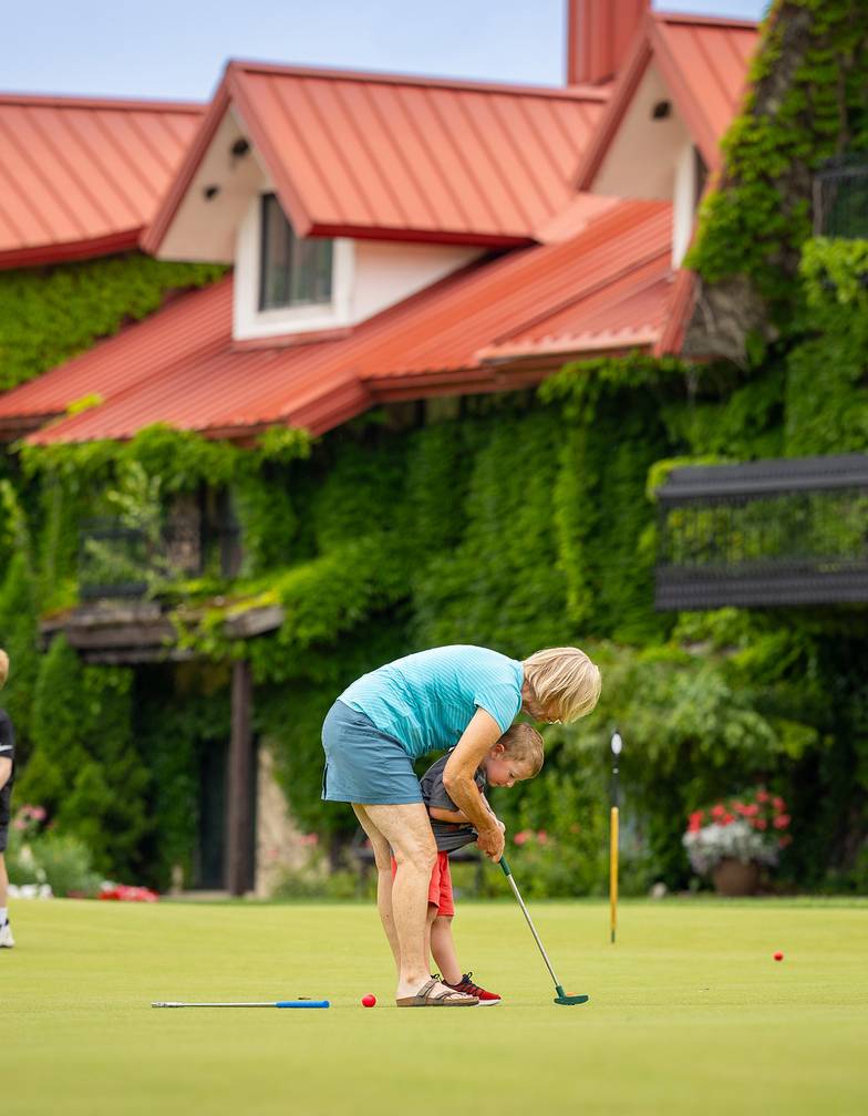 A family putting on the Back Yaird Putting Green