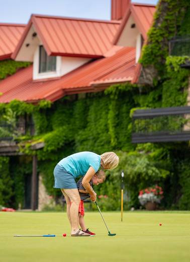 A family putting on the Back Yaird Putting Green