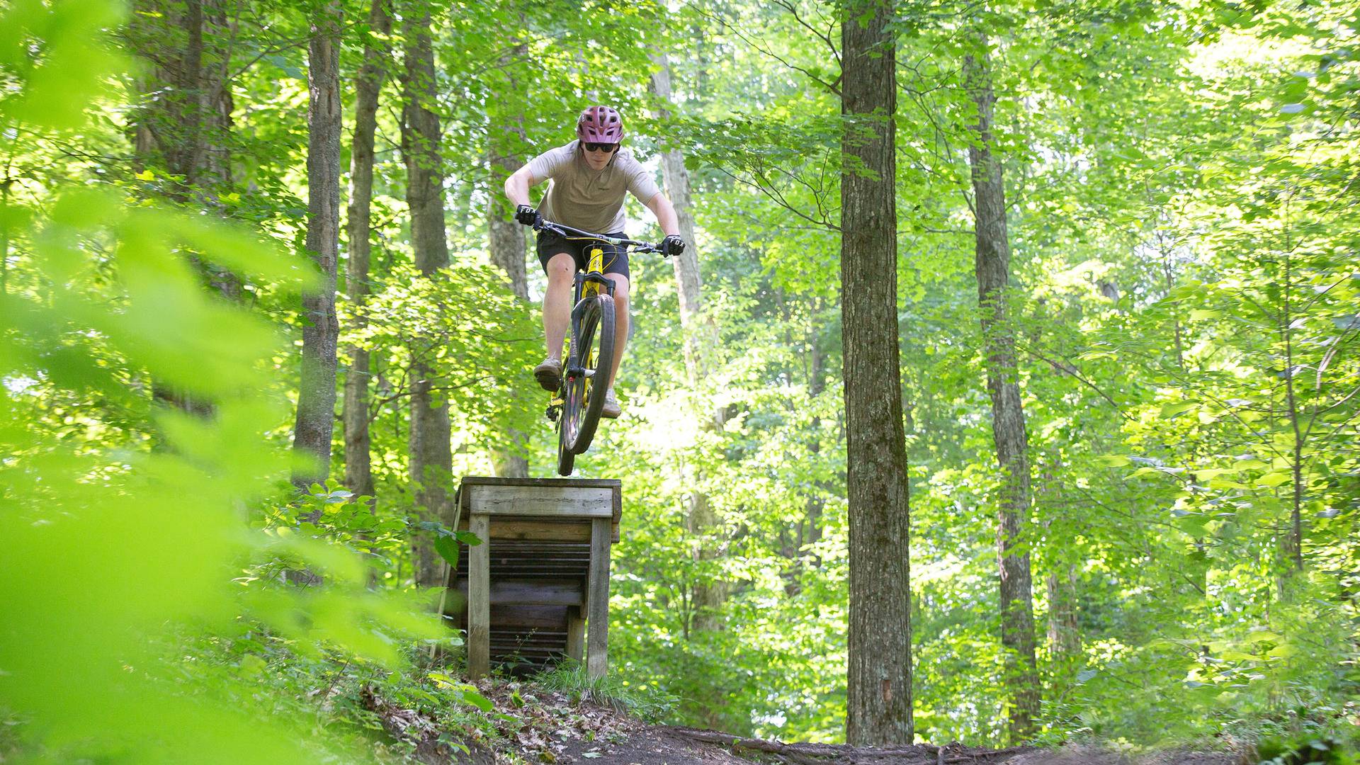A mountain biker on a wooden jump