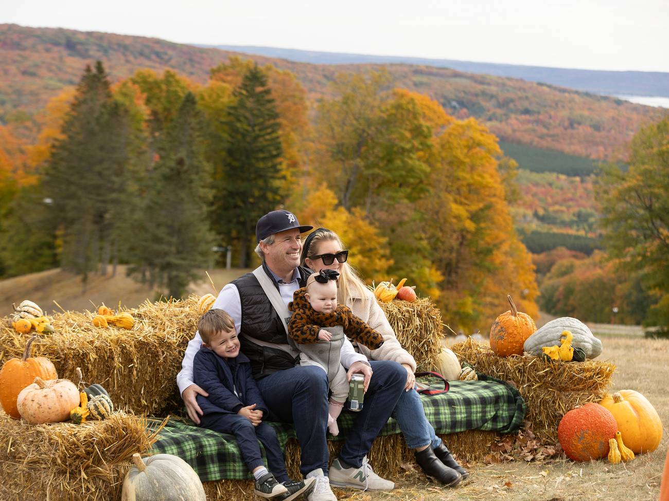 A family posing on a hay bale at The Highlands Harvest Fest
