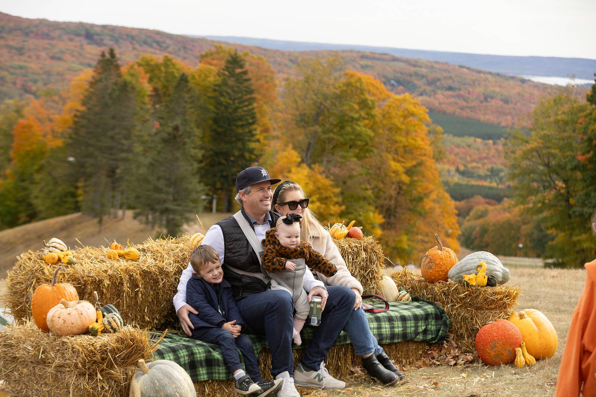 A family posing on a hay bale at The Highlands Harvest Fest