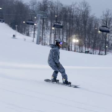 A snowboarder during nighttime at The Highlands