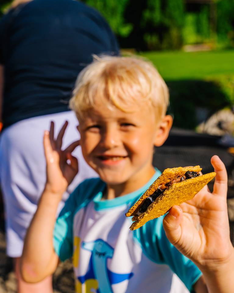A boy holding a s'more at The Highlands