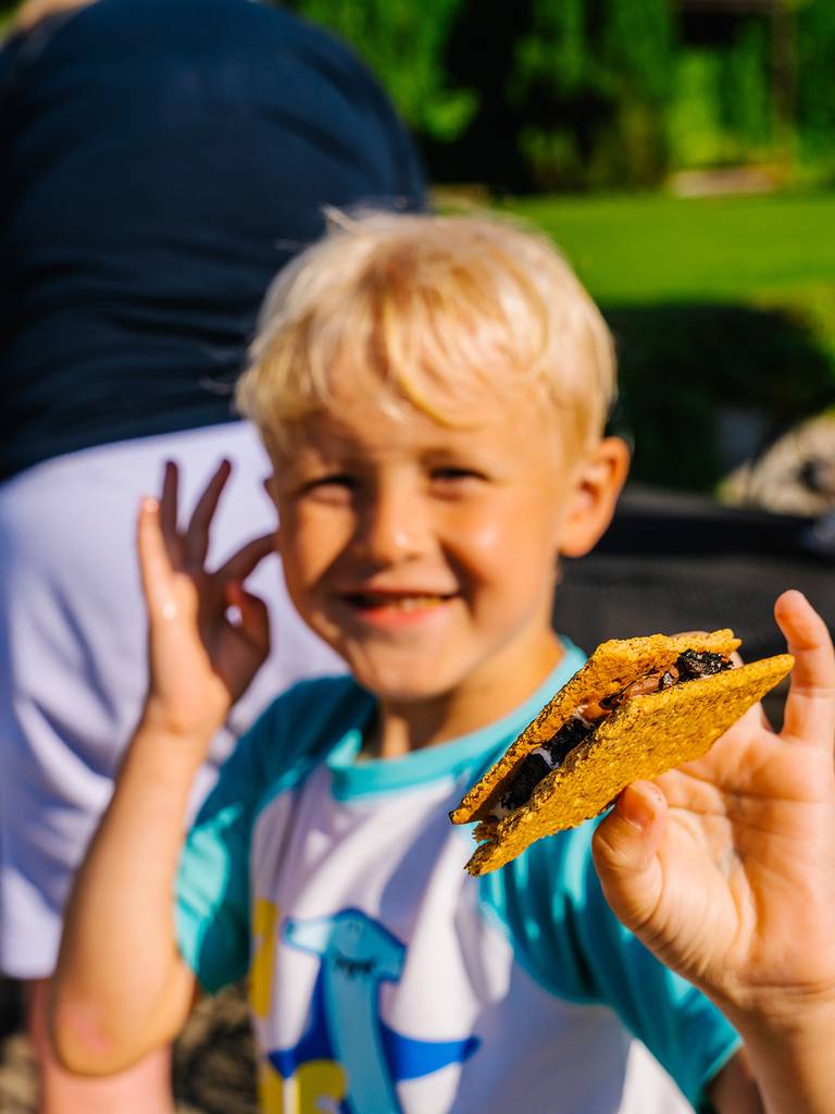 A boy holding a s'more at The Highlands