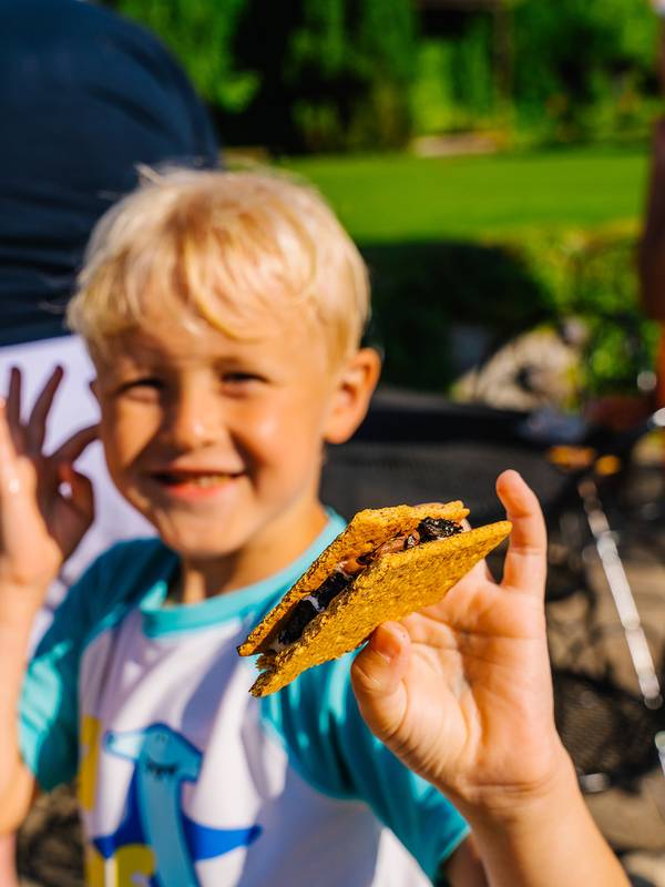 A boy holding a s'more at The Highlands