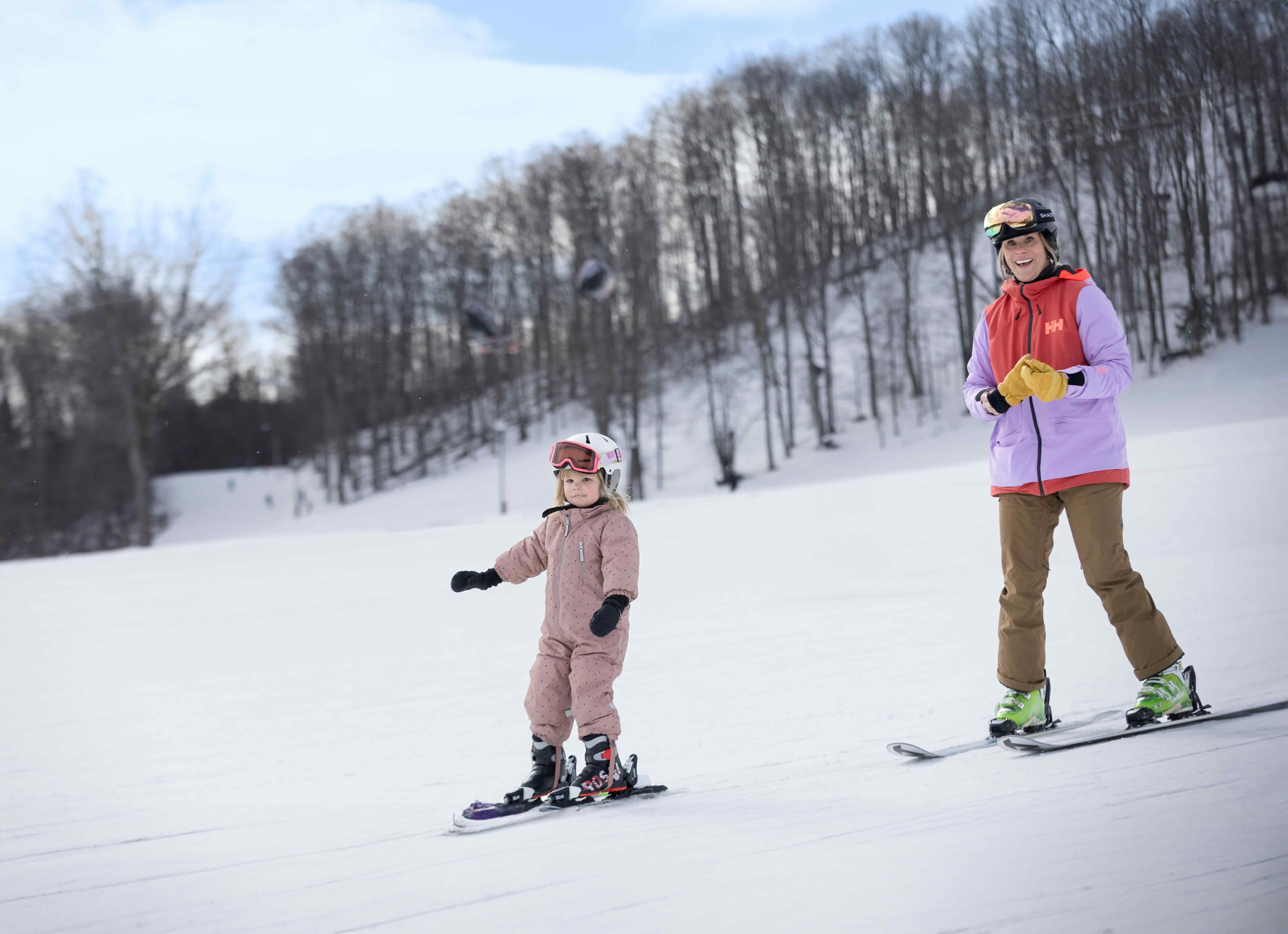 A mom and daughter in ski gear