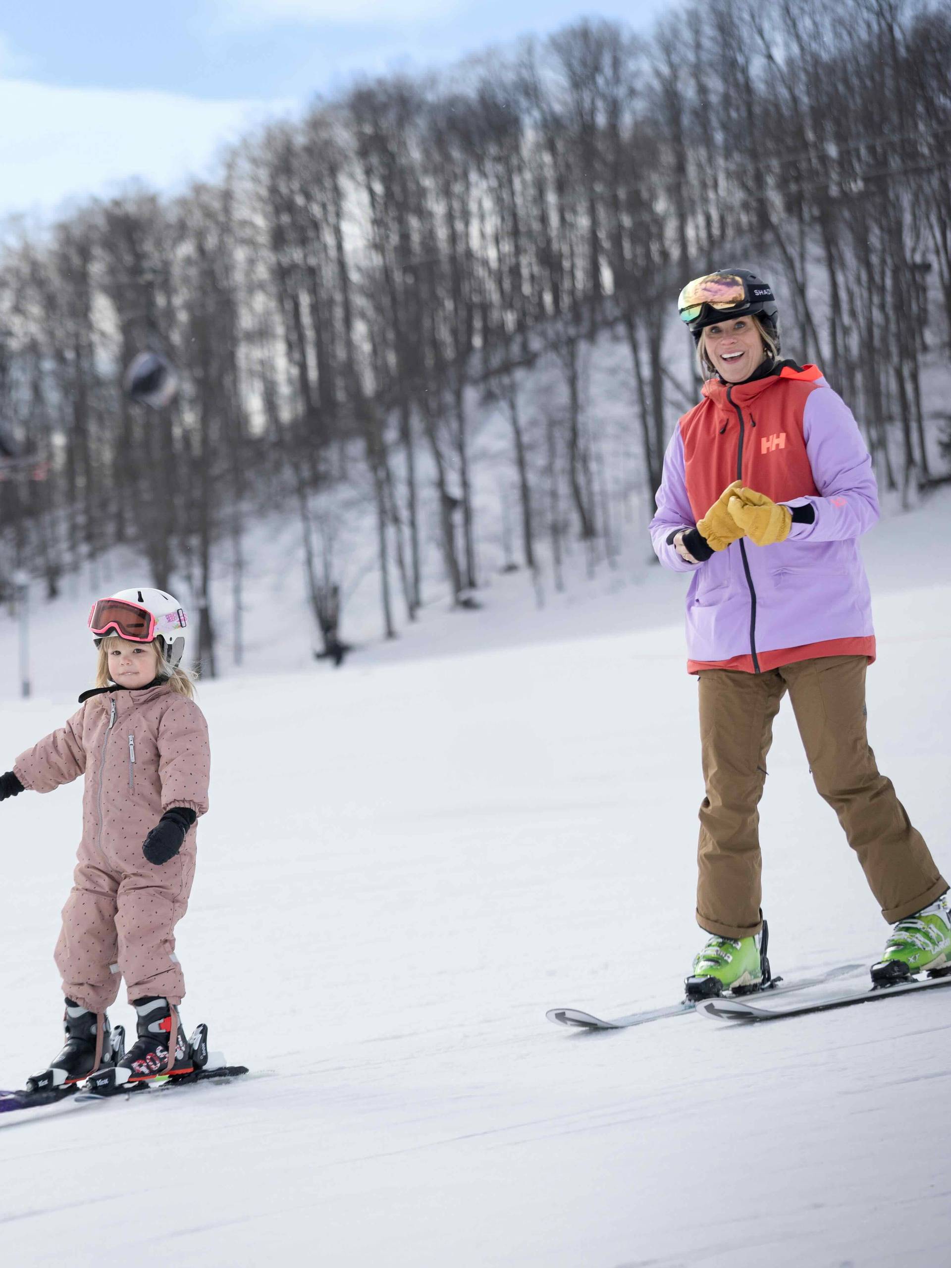 A mom and daughter in ski gear