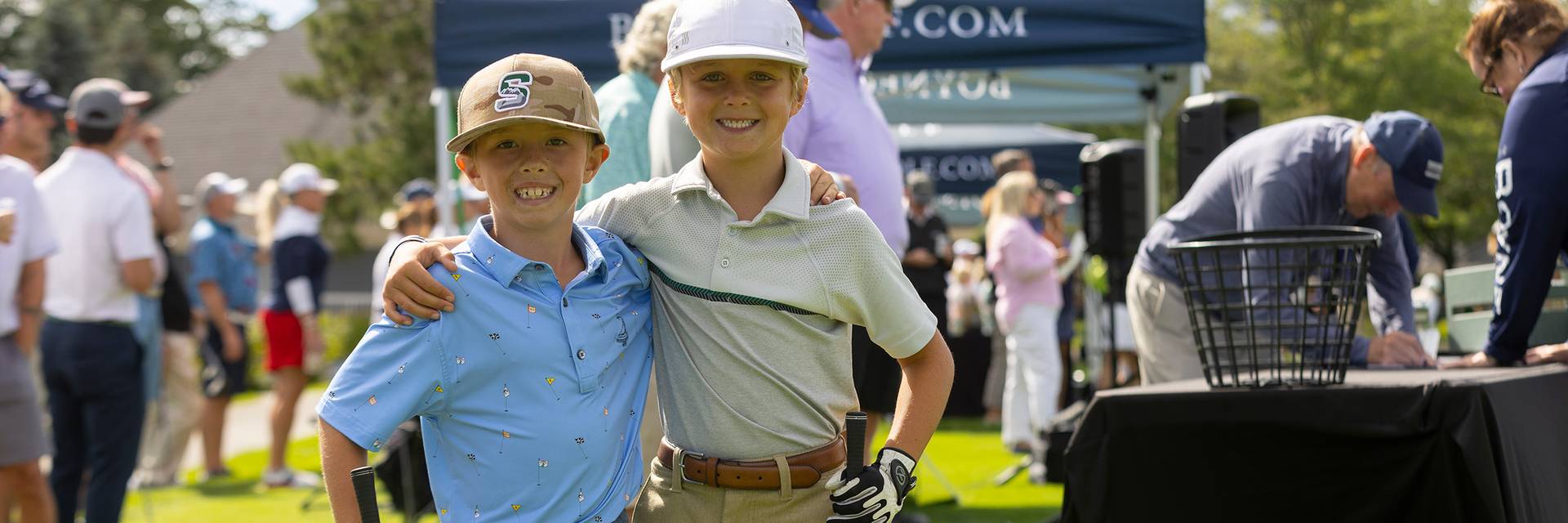 Two kids posing with golf clubs