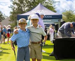 Two kids posing with golf clubs