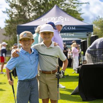 Two kids posing with golf clubs