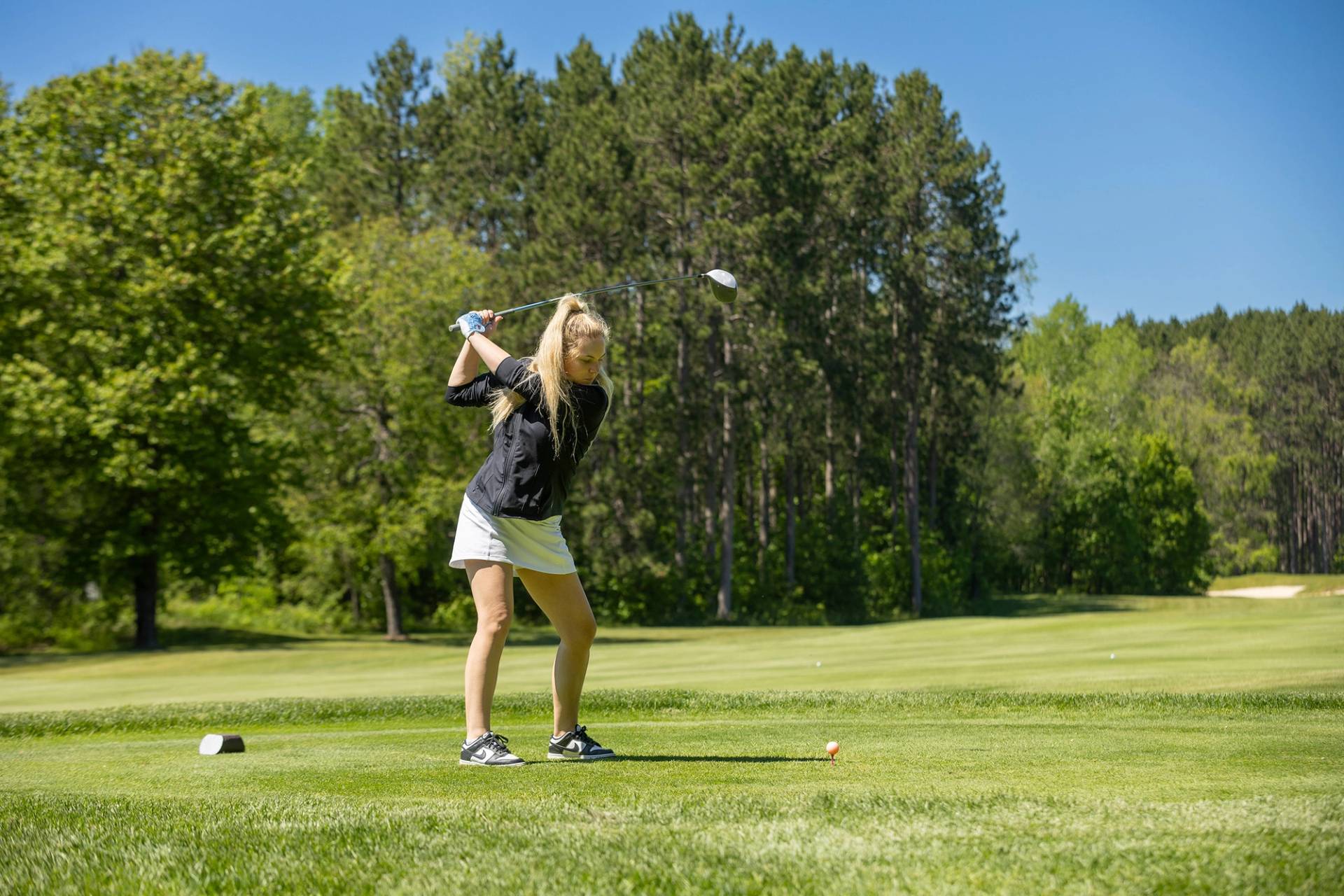 A woman golfing at The Highlands