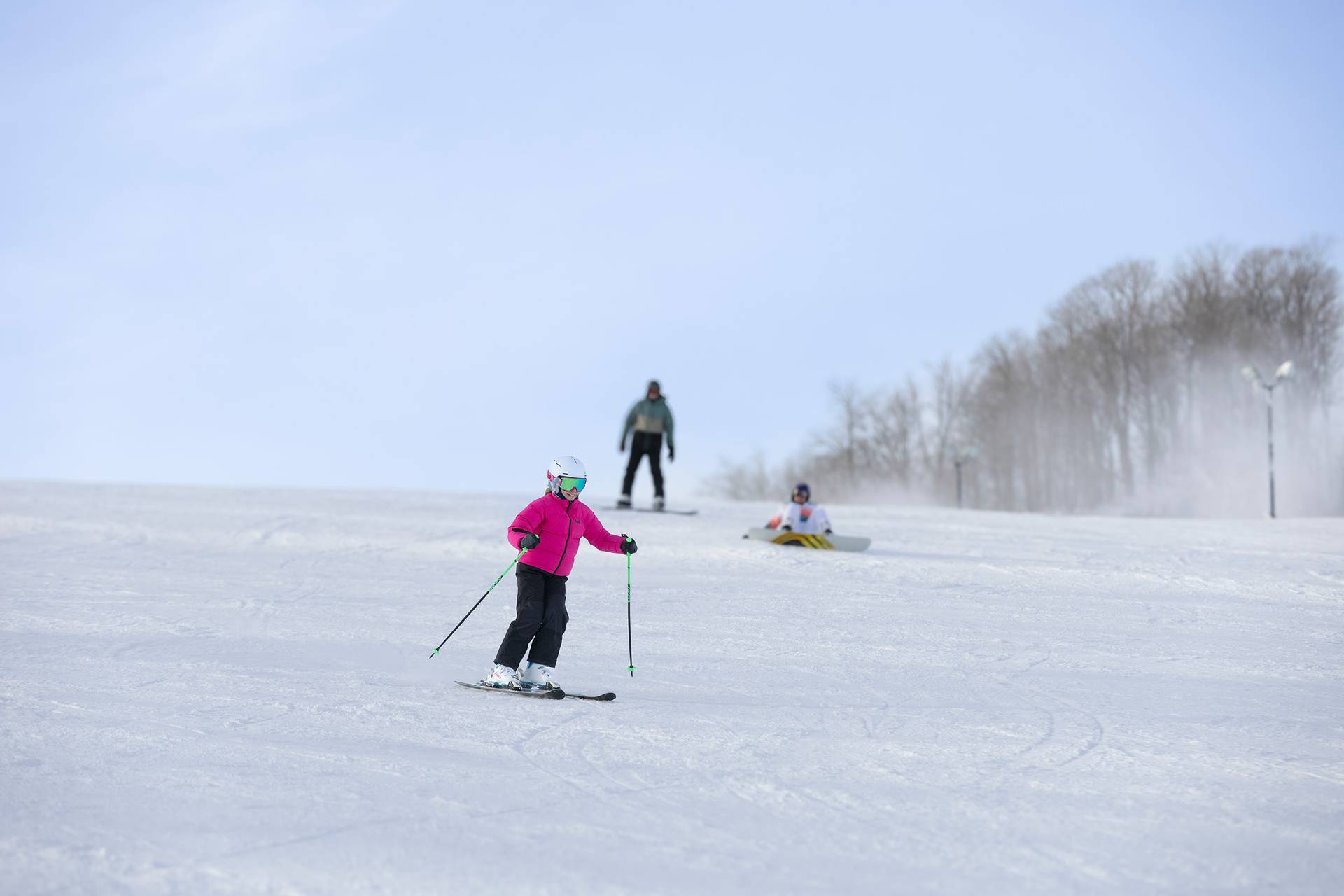 Two kids high-fiving in ski gear at The Highlands