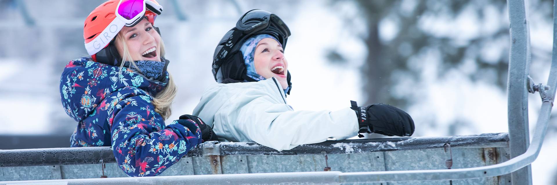 Two women in ski gear siting on a chairlift