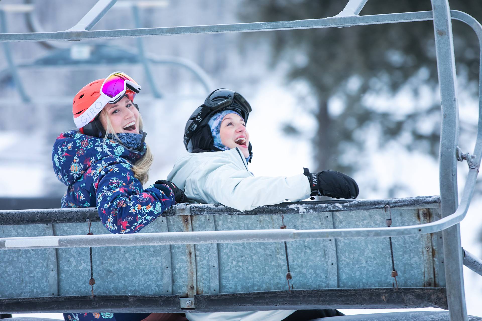 Two women in ski gear siting on a chairlift