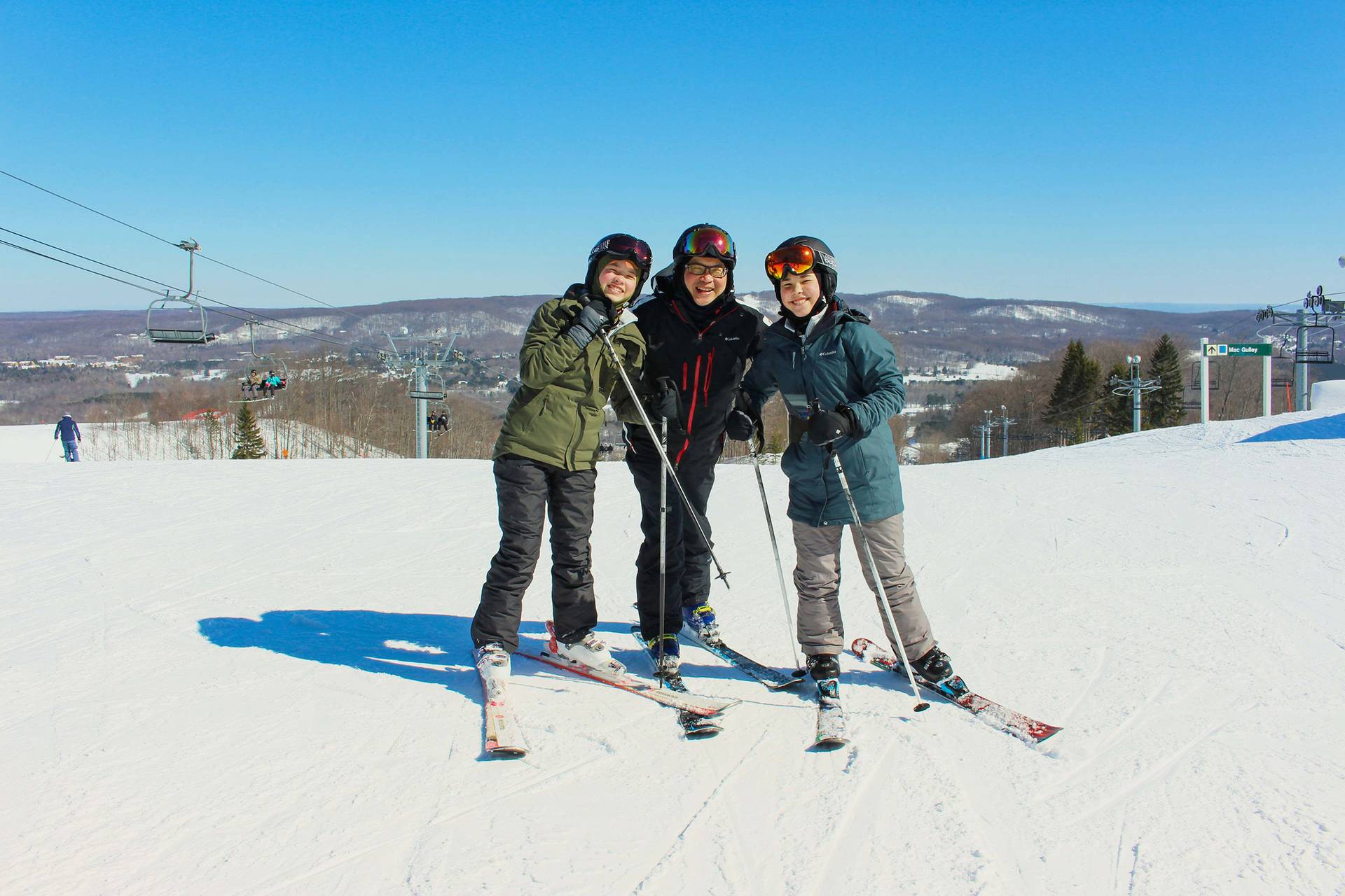 A group of skiers posing at the top of the slopes at The Highlands
