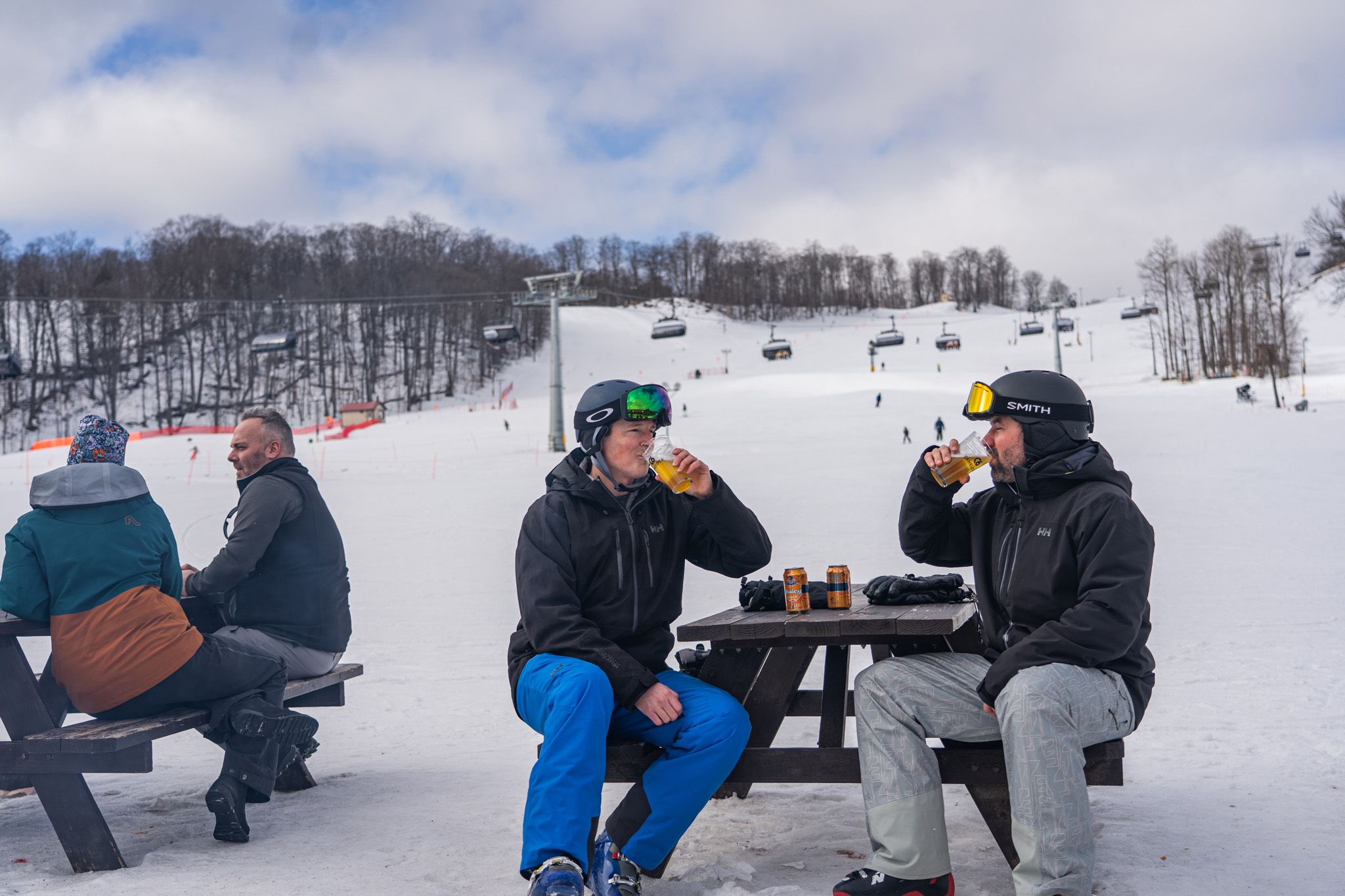 Two skiers drinking outside at The Highlands