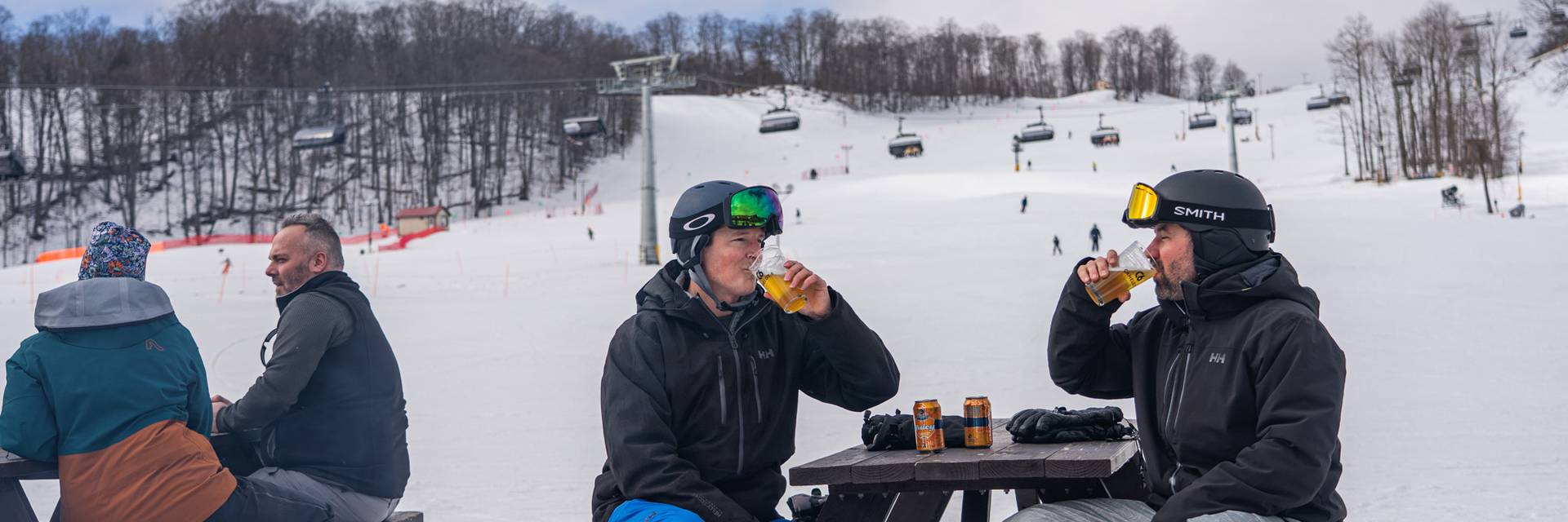 Two skiers drinking outside at The Highlands