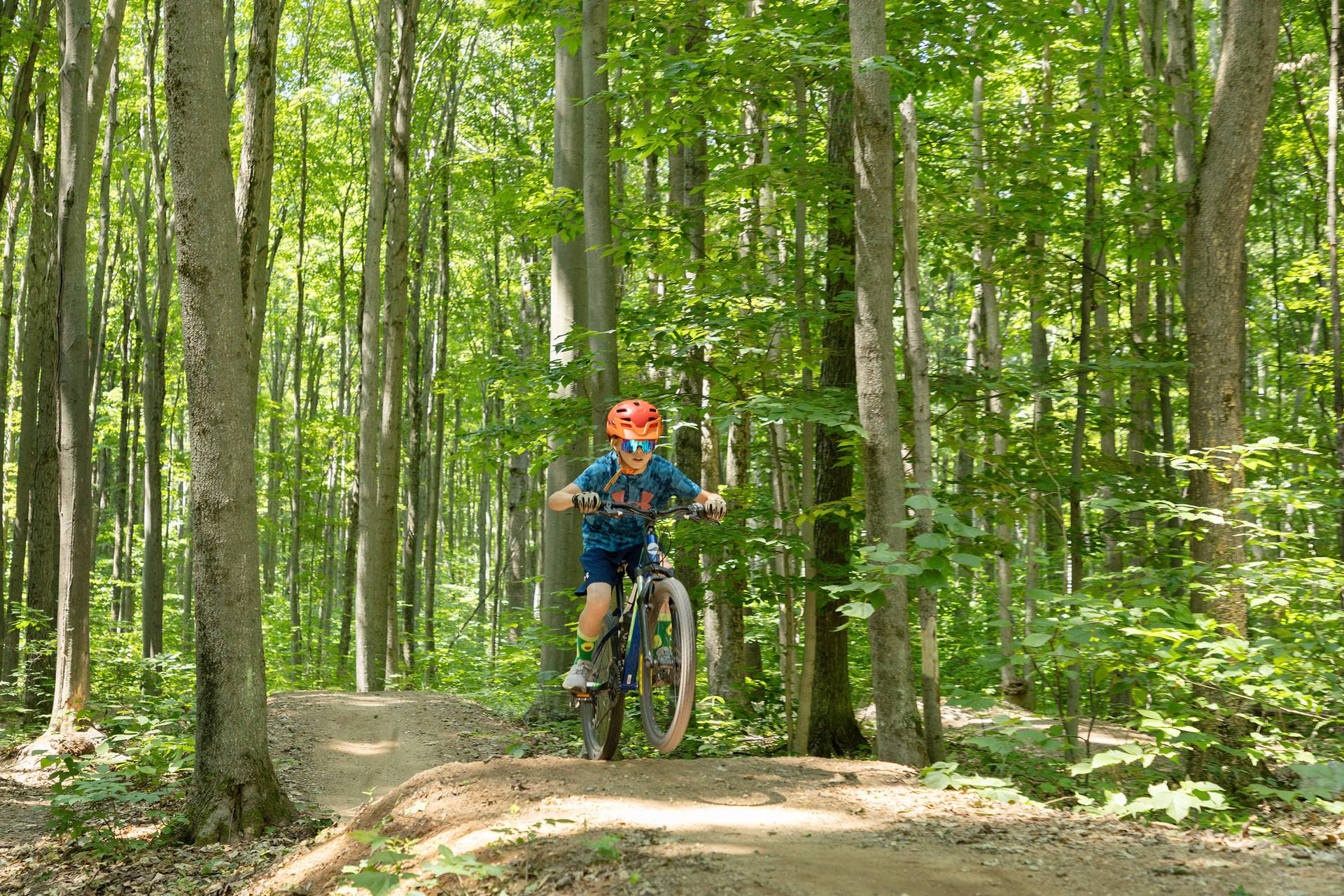 A child biking on the Swayze trail at The Highlands Bike Park