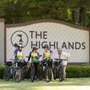 Women bikers posing in front of The Highlands sign