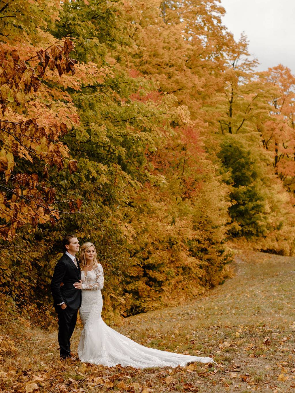 A couple posing near a chairlift in fall