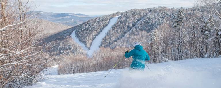 A skier in a blue jacket at Sunday River