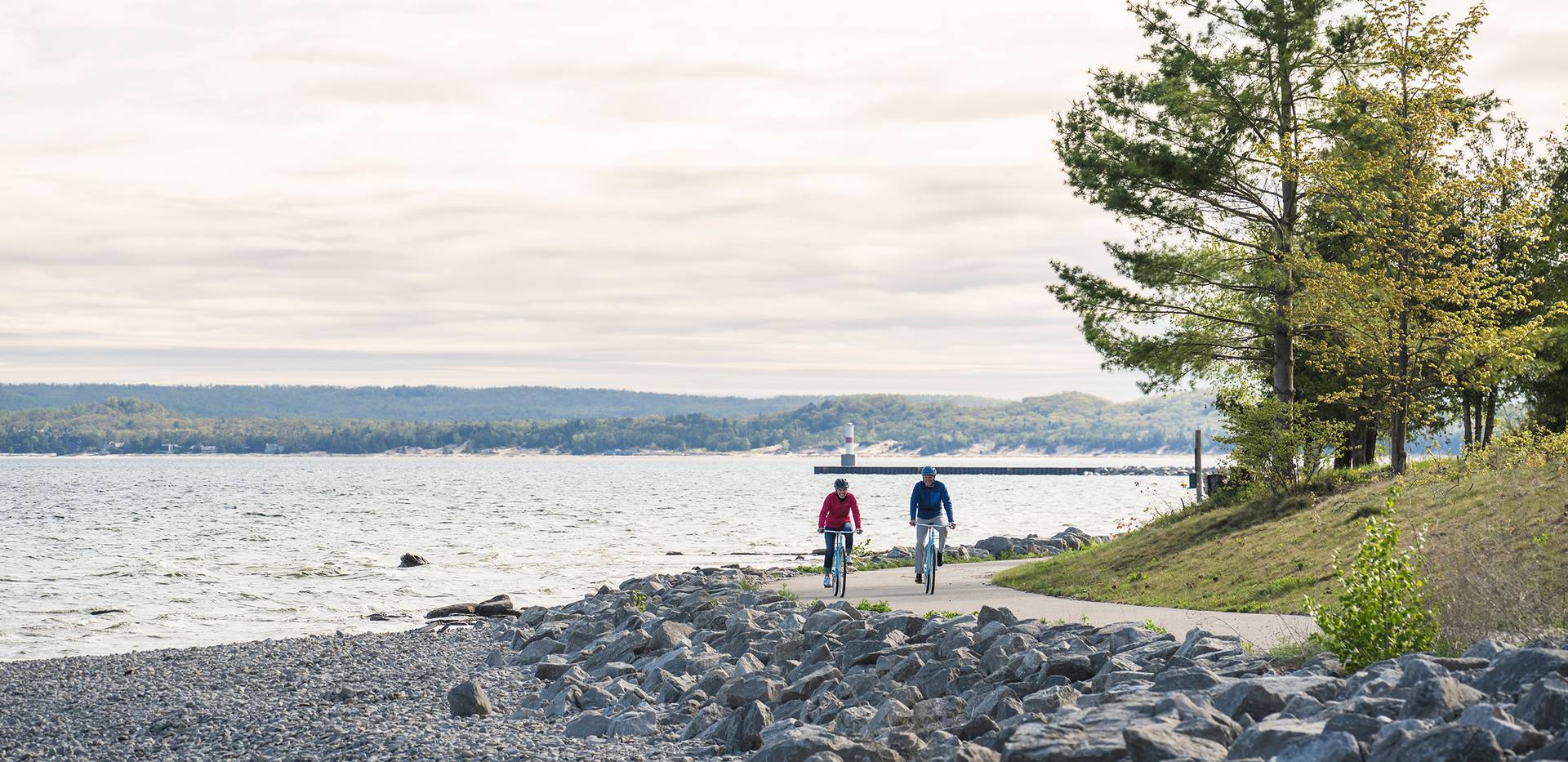 Two bikers on the Little Traverse Wheelway near the water