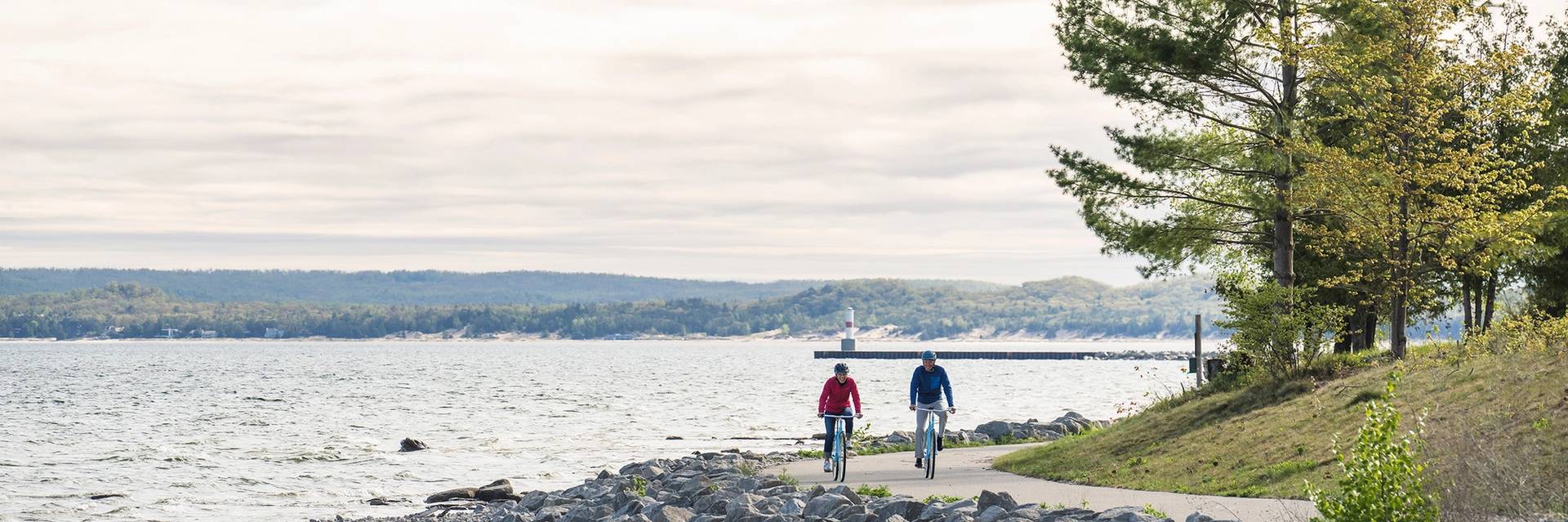 Two bikers on the Little Traverse Wheelway near the water