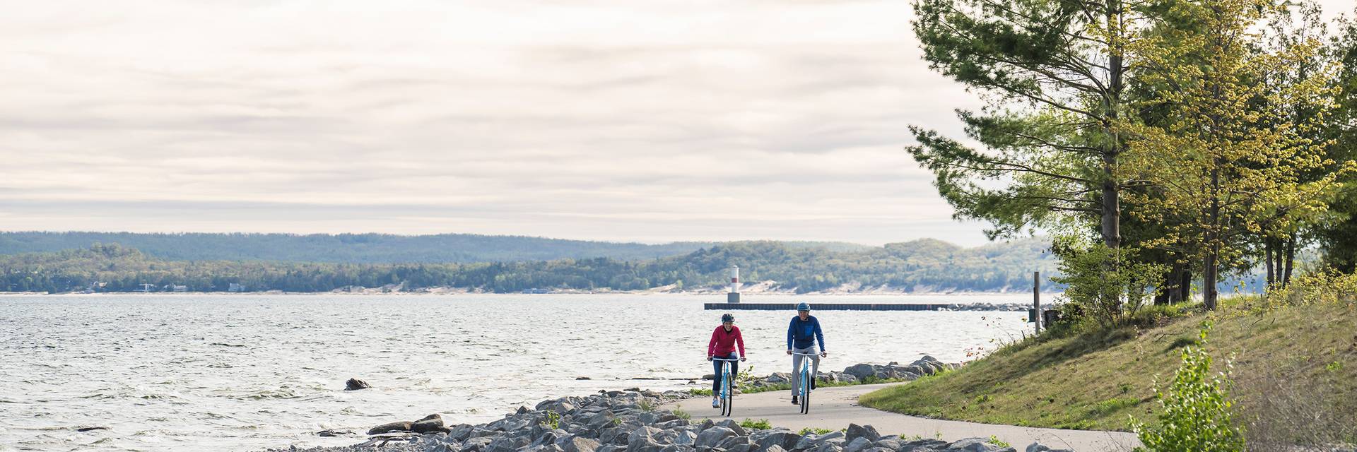 Two bikers on the Little Traverse Wheelway near the water