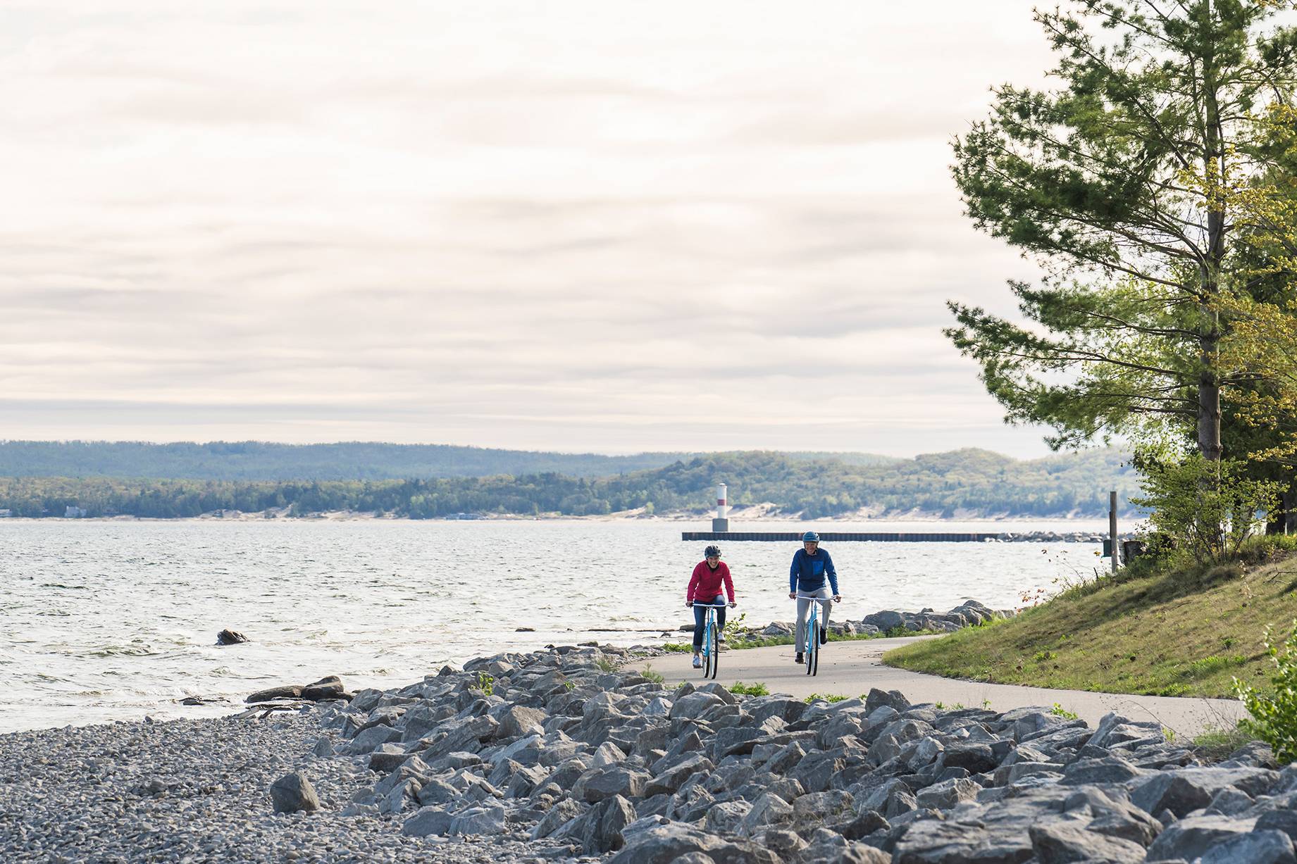 Two bikers on the Little Traverse Wheelway near the water