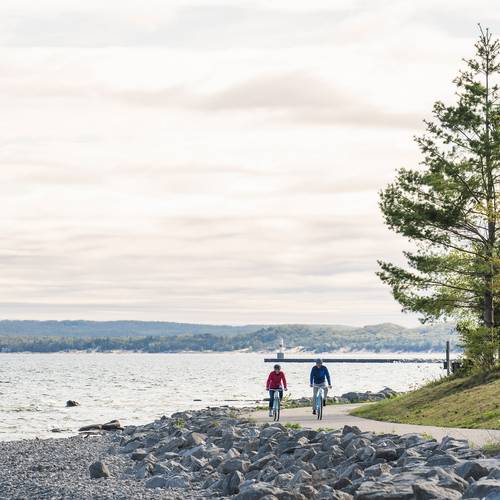 Two bikers on the Little Traverse Wheelway near the water