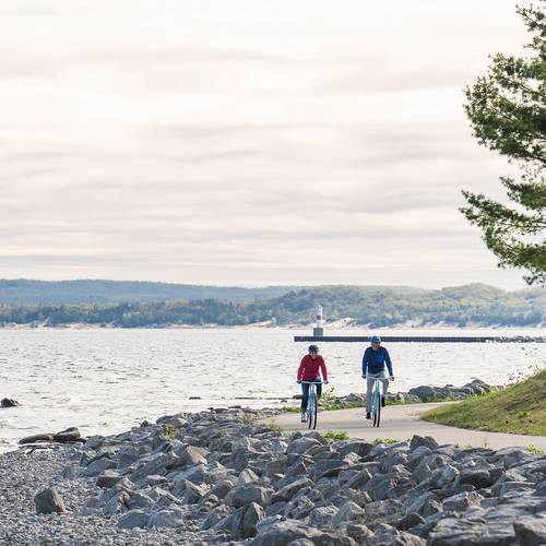 Two bikers on the Little Traverse Wheelway near the water