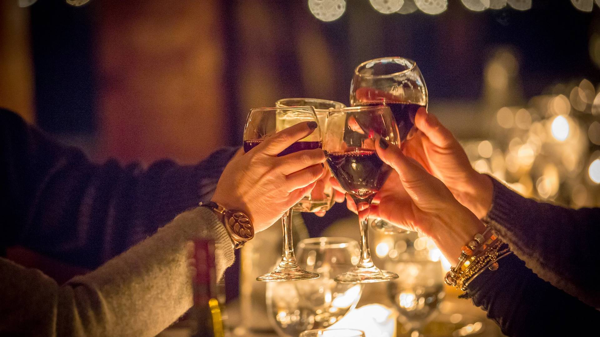 A group cheering with their wine glasses during the Aonach Mor Moonlight Dinner at The Highlands