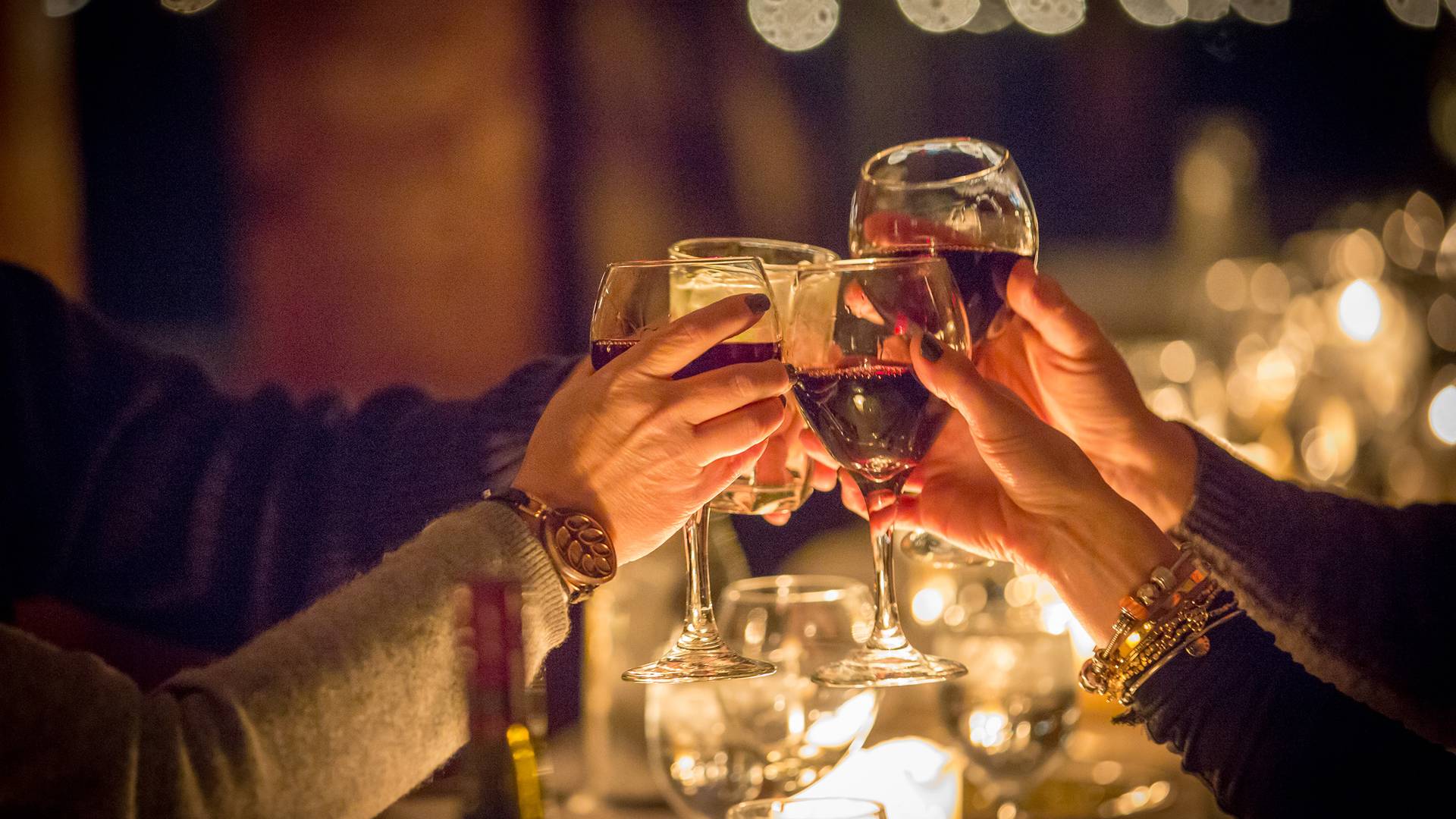 A group cheering with their wine glasses during the Aonach Mor Moonlight Dinner at The Highlands