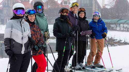 Women posing in ski gear during a Highlands Her Turn Clinic