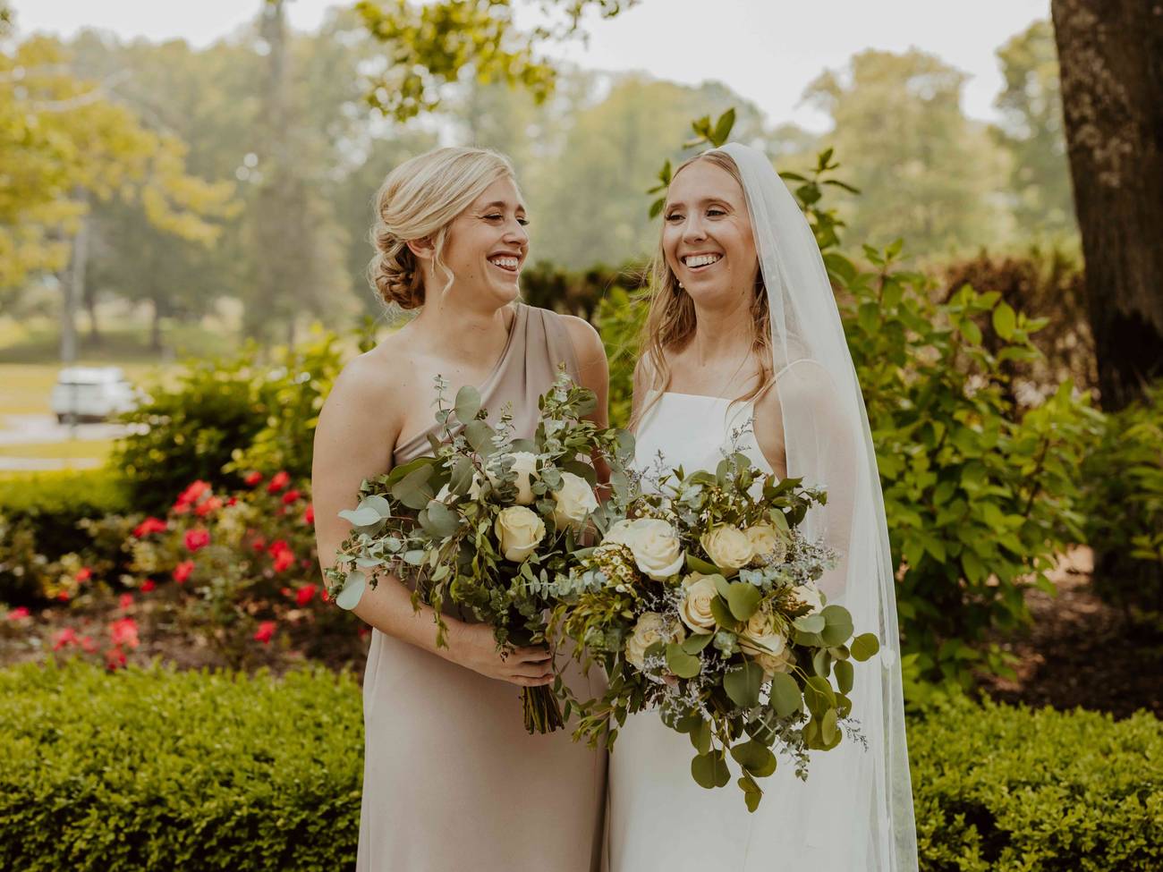 A bride and bridesmaid posing and smiling