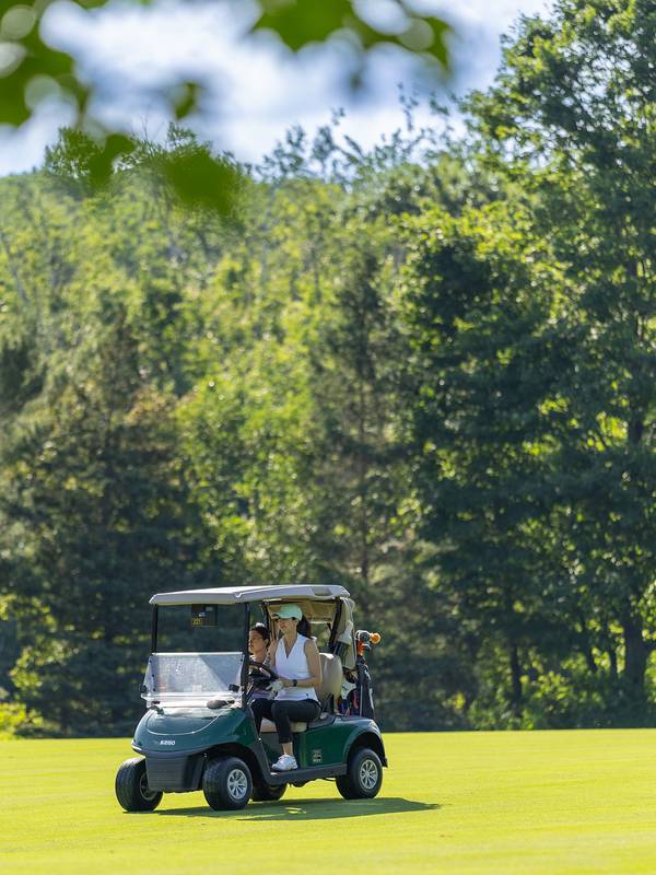 Two women in a golf cart